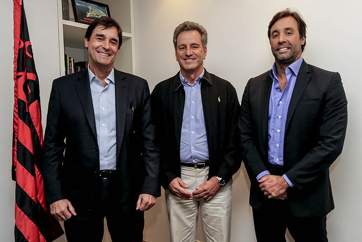 Gabriel Pentagna Guimarães (diretor presidente do BS2), à esquerda, e Rodrigo Pentagna Guimarães (vice-presidente comercial do BS2), à direita do presidente Rodolfo Landim