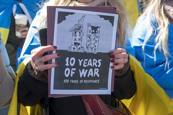 Mulher segura uma placa mostrando 10 anos de guerra desde a anexação da Crimeia pela Rússia em um comício pela Ucrânia no segundo aniversário da invasão russa da Ucrânia na Times Square em fevereiro, na cidade de Nova York