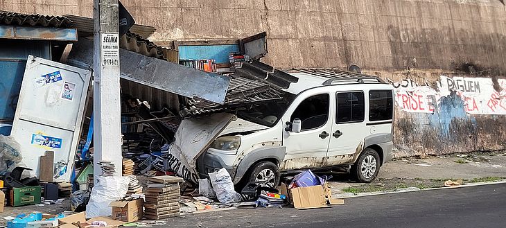 Após o acidente, um dos carros se chocou e destruiu uma barraca de livros