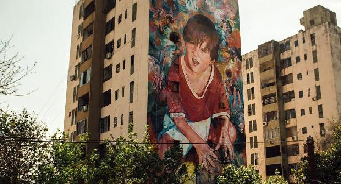 Mural em Rosário retrata Lionel Messi ainda criança segurando uma bola de futebol